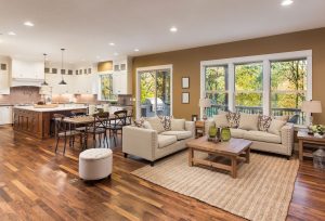 a living room filled with furniture next to a kitchen.